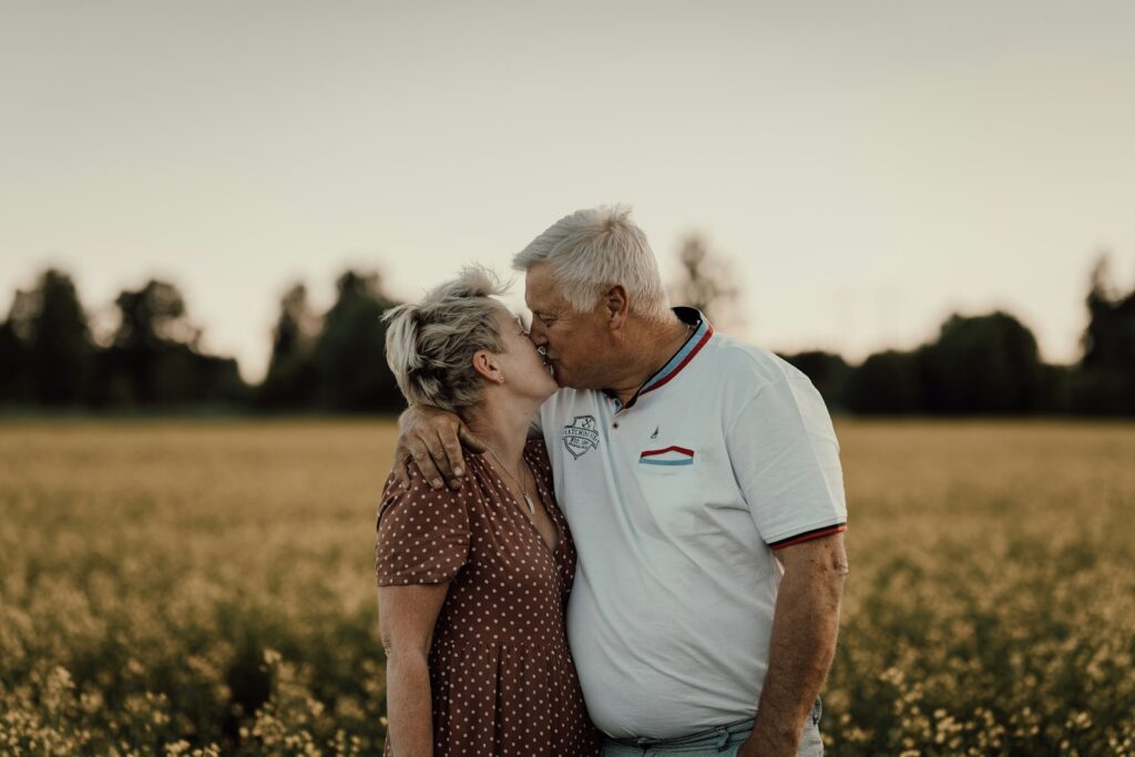 a man and woman kissing in a field